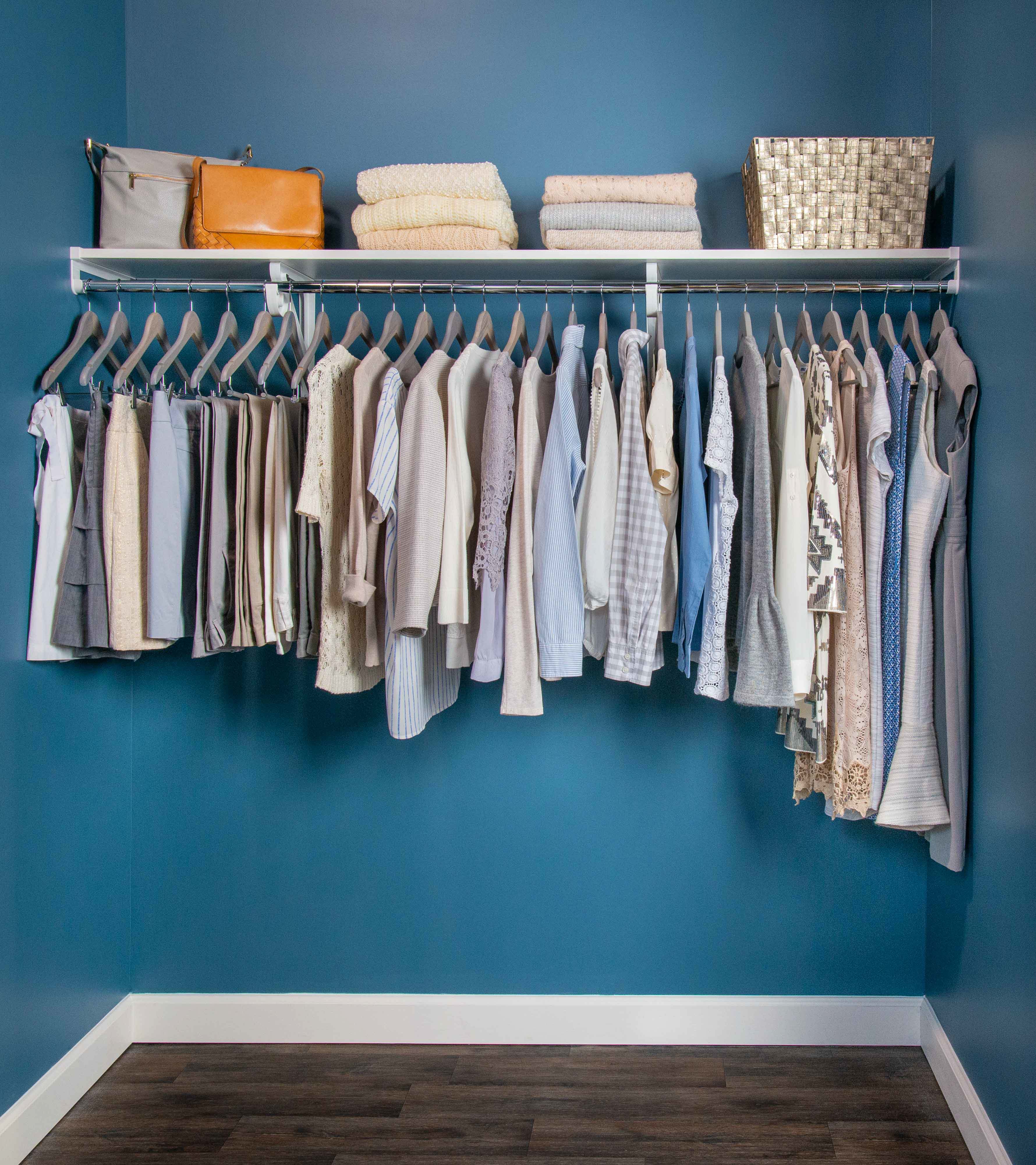 VUE Reach-In Closet in White with hanging clothes, basket and blue wall.