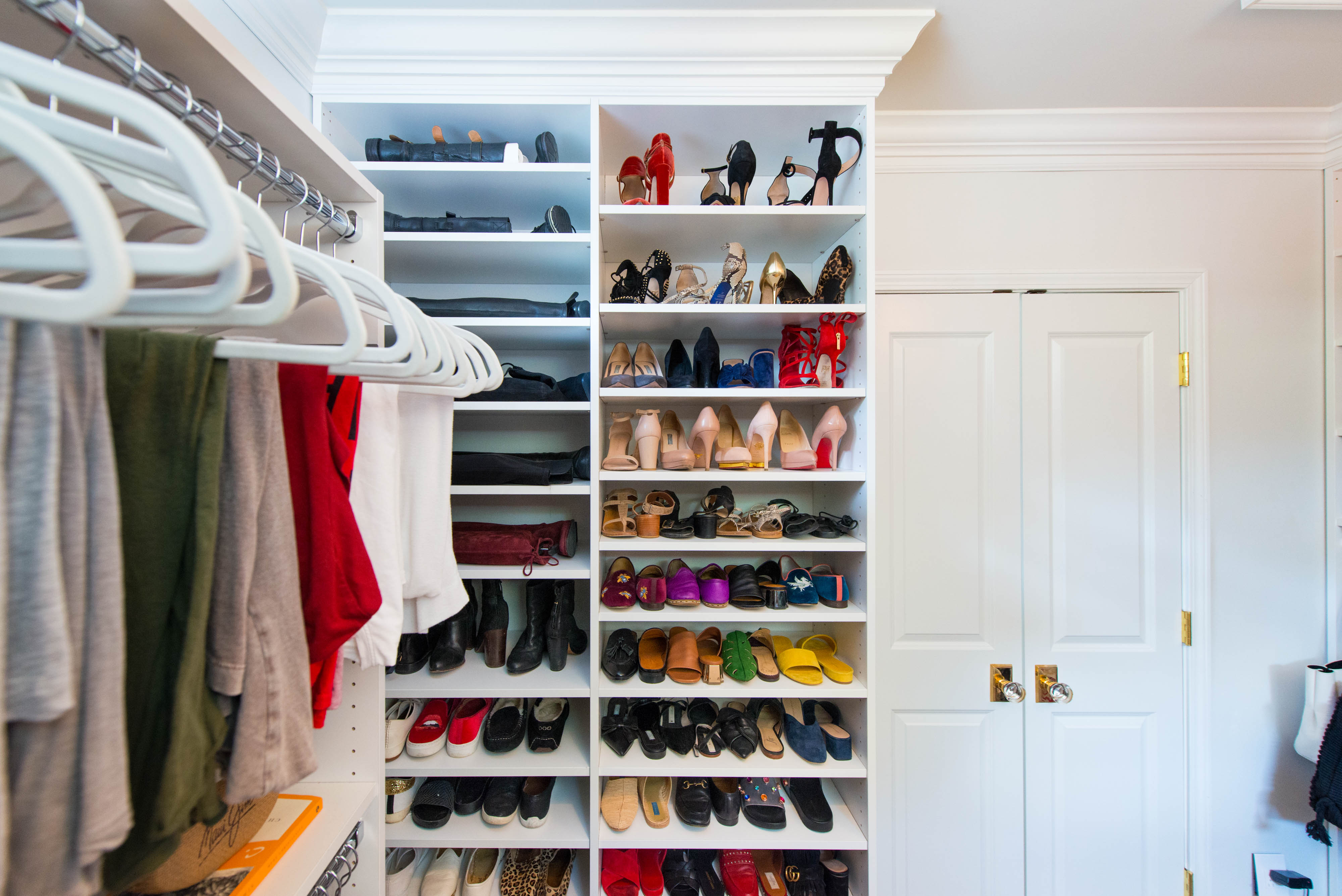 Classica Closet in White with shelves with women's shoes and hangers with women's clothing.