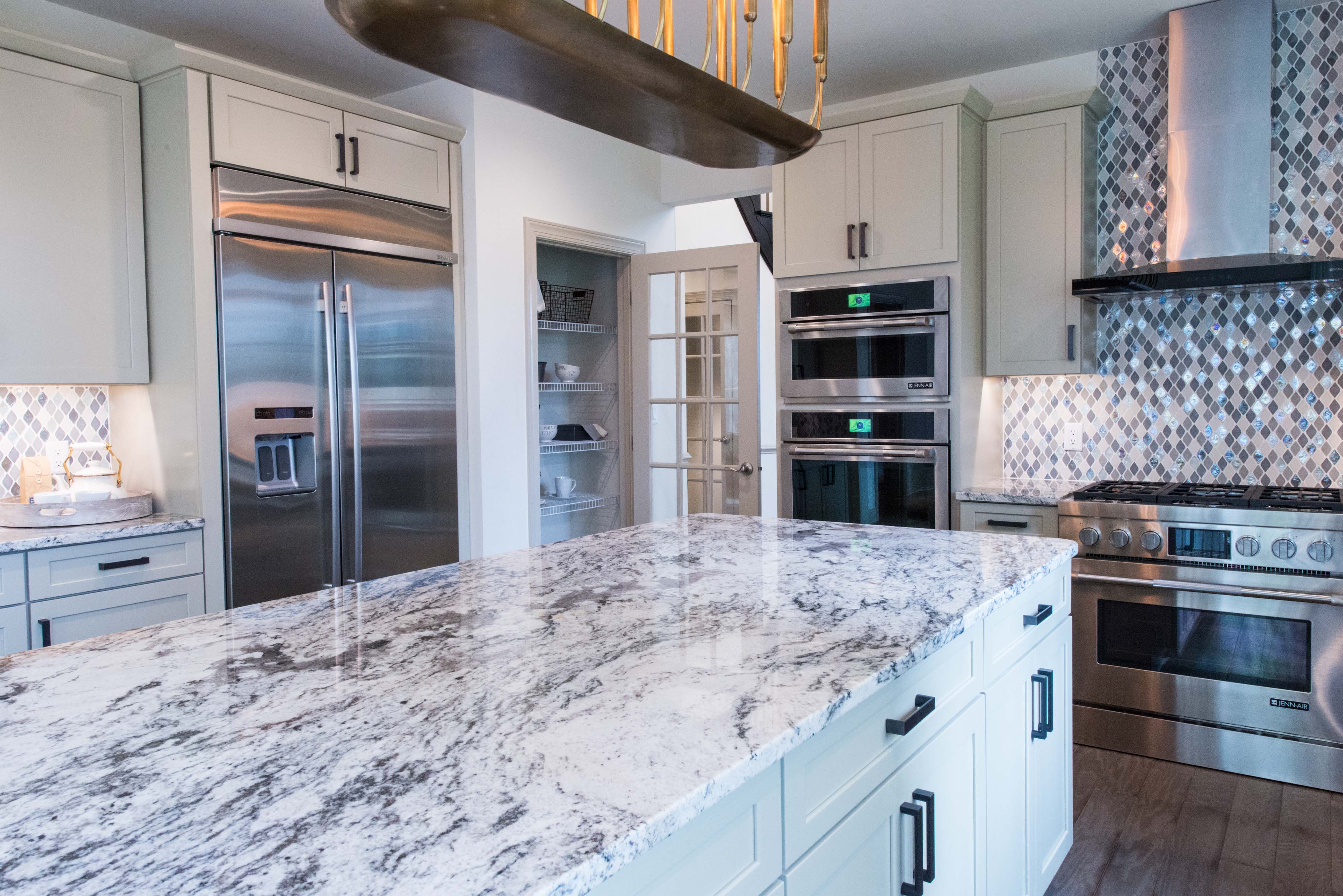 Kitchen with cleared off island and white cabinets.