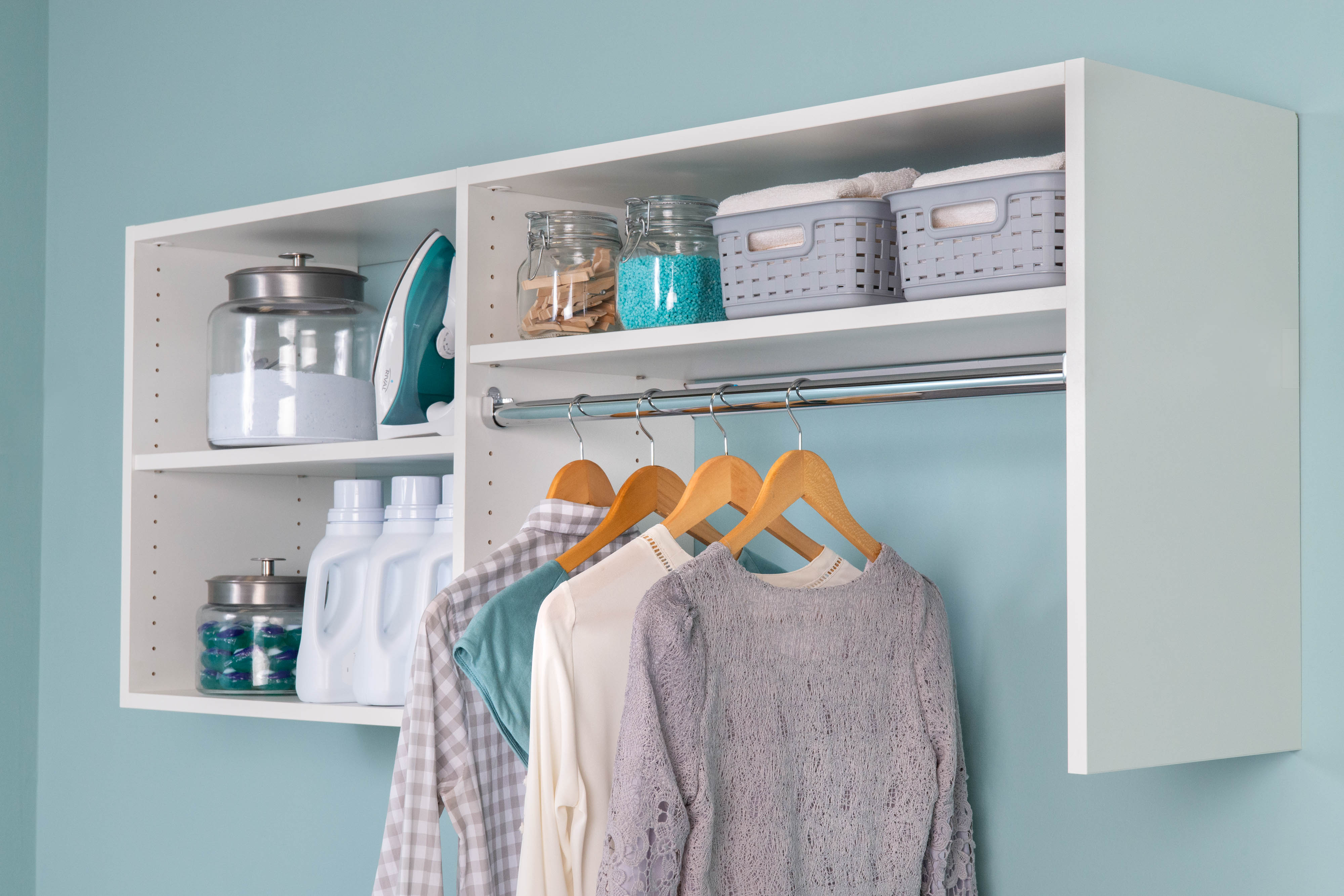 Select White Laundry Shelving with hanging shirts, laundry cleaning products, and supplies.