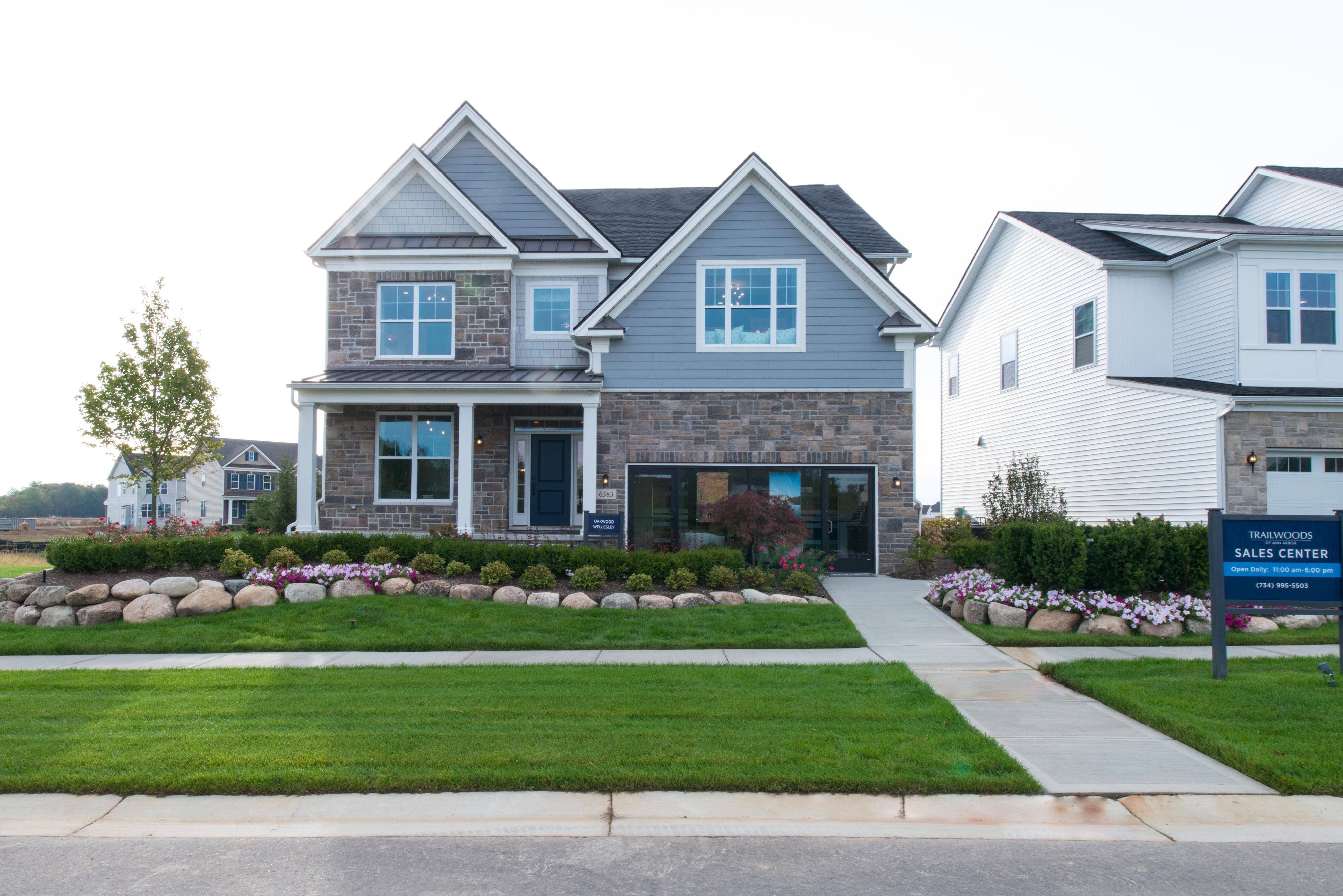 Toll Brothers Model Home with landscaping, garage open, and sign on far right 