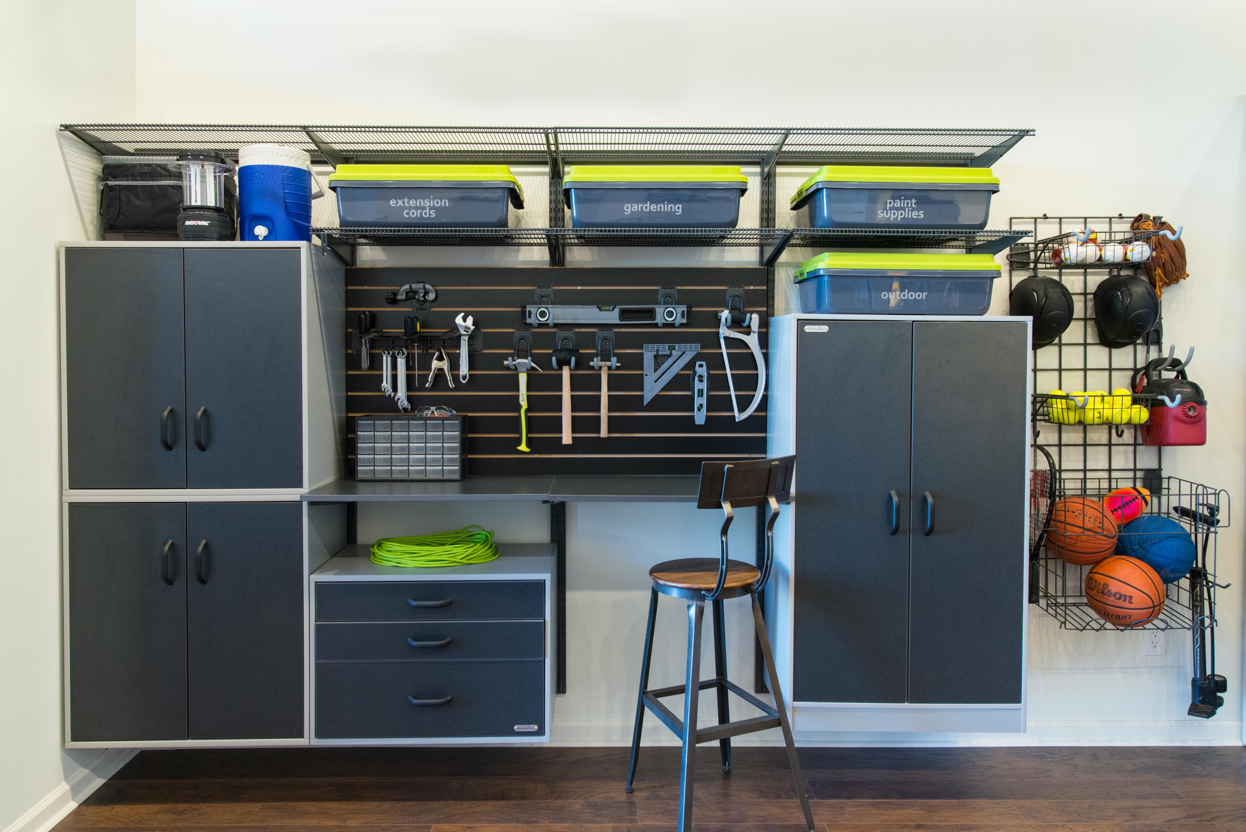 freedomRail Garage with cabinets, sports balls, and work bench.