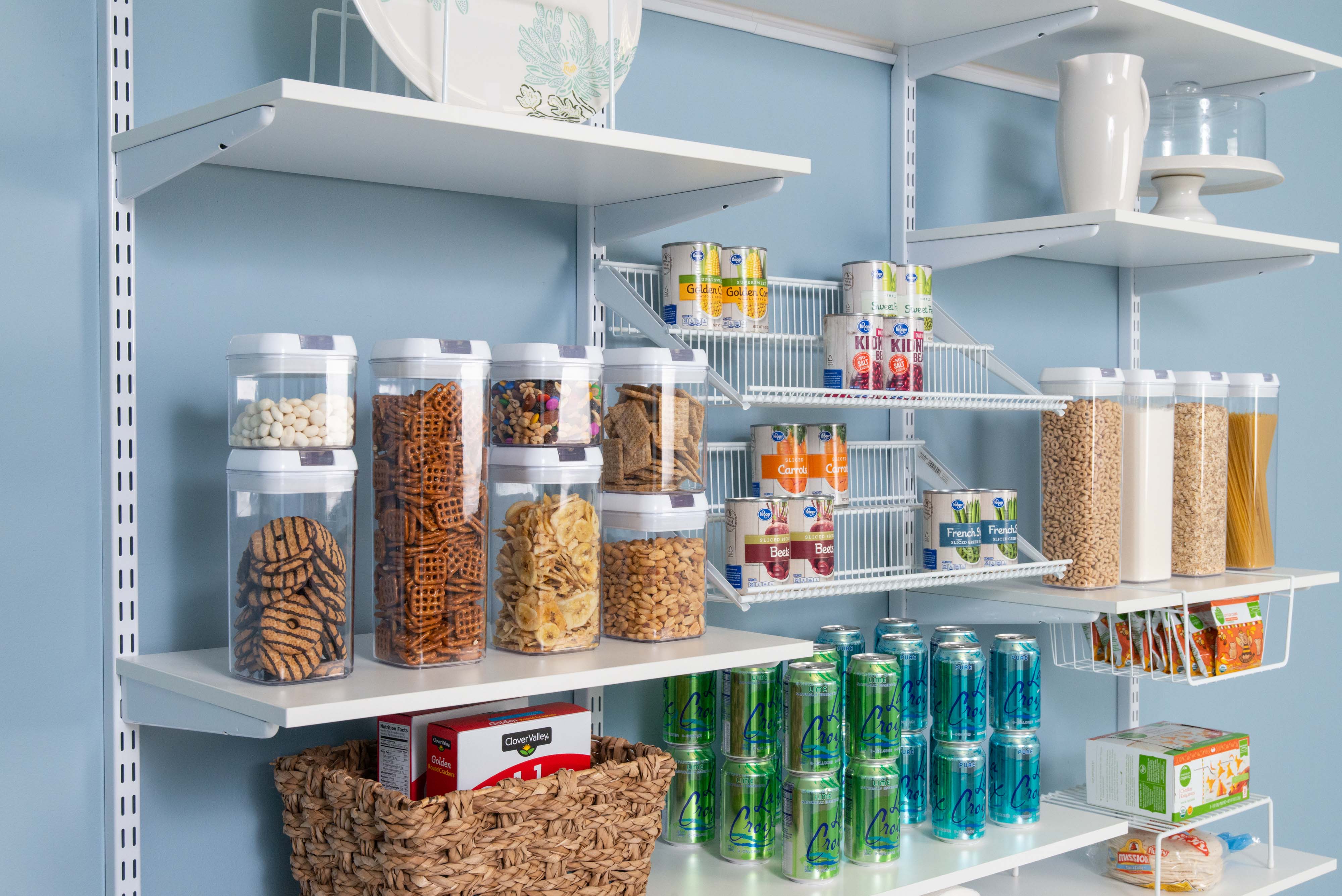 freedomRail Pantry in White with La Croix's, clear containers with dry goods, and baskets.