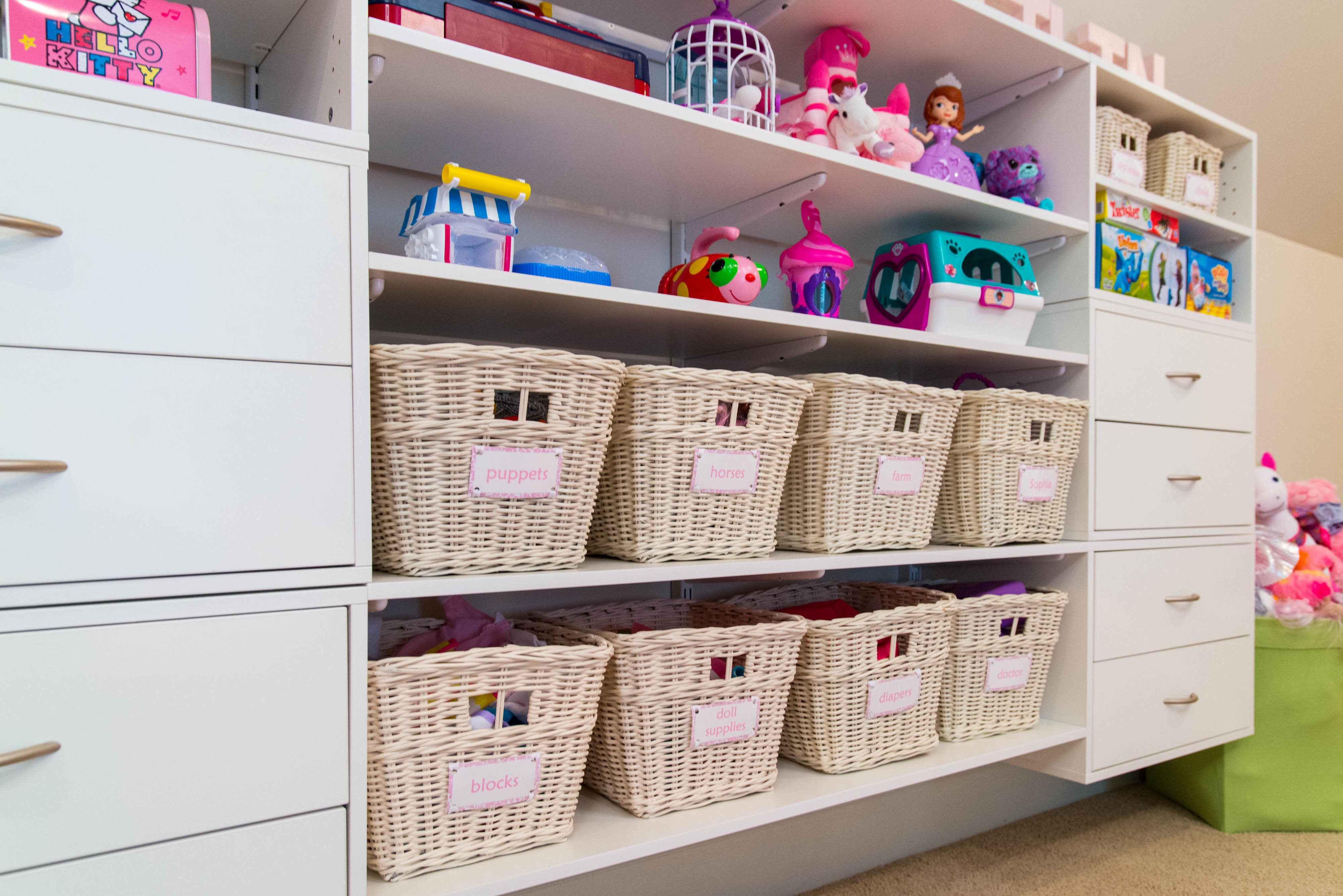 freedomRail Playroom System in White with 8 labeled baskets, shelves full of colorful toys.