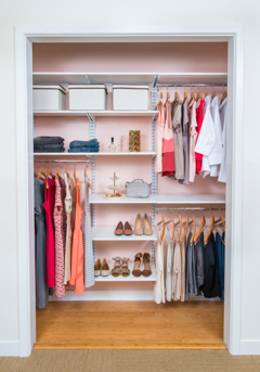 freedomRail Reach-in Closet in White with women's clothes and pink background.