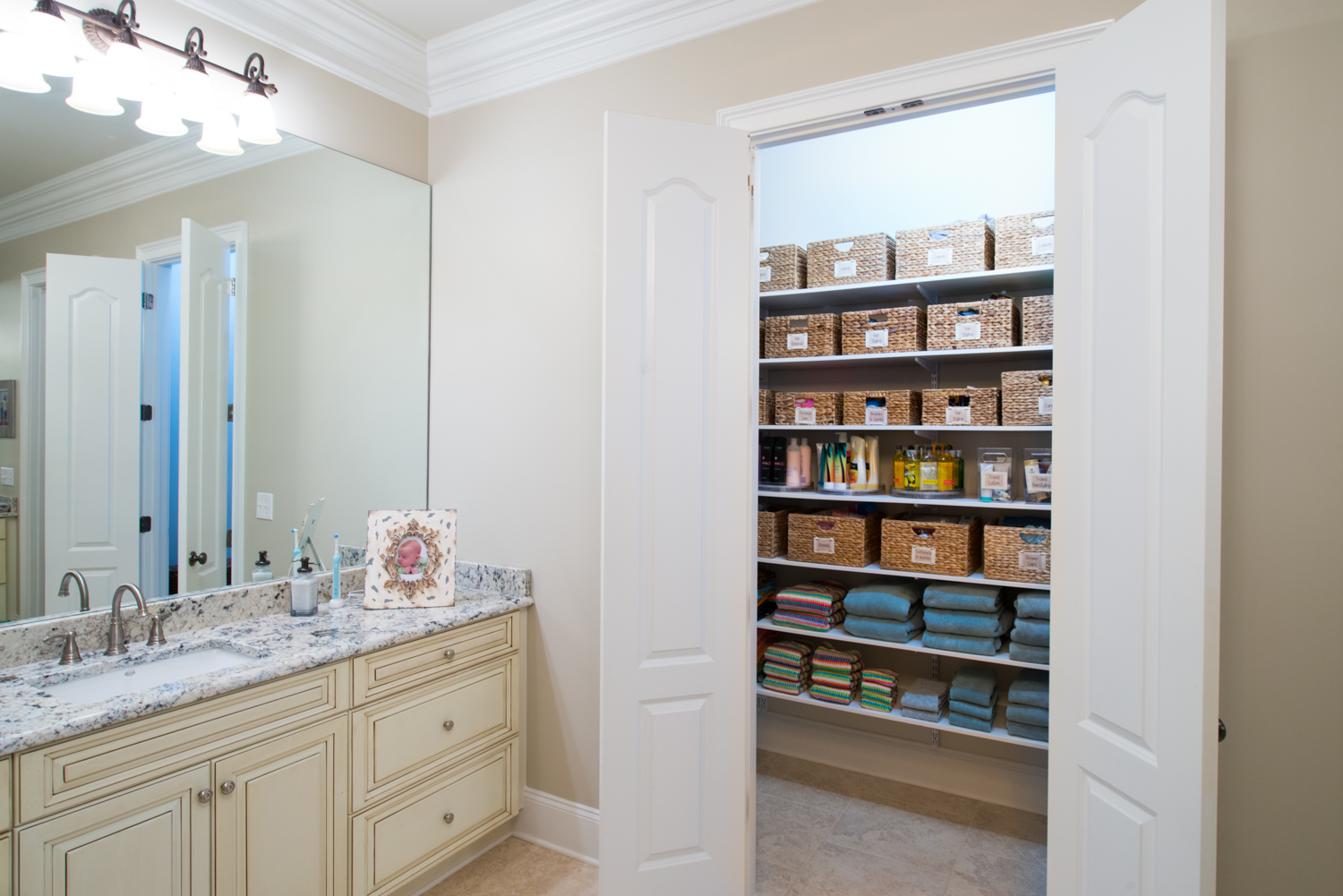 freedomRail Reach-in Closet in White with toiletries and bath towels. 