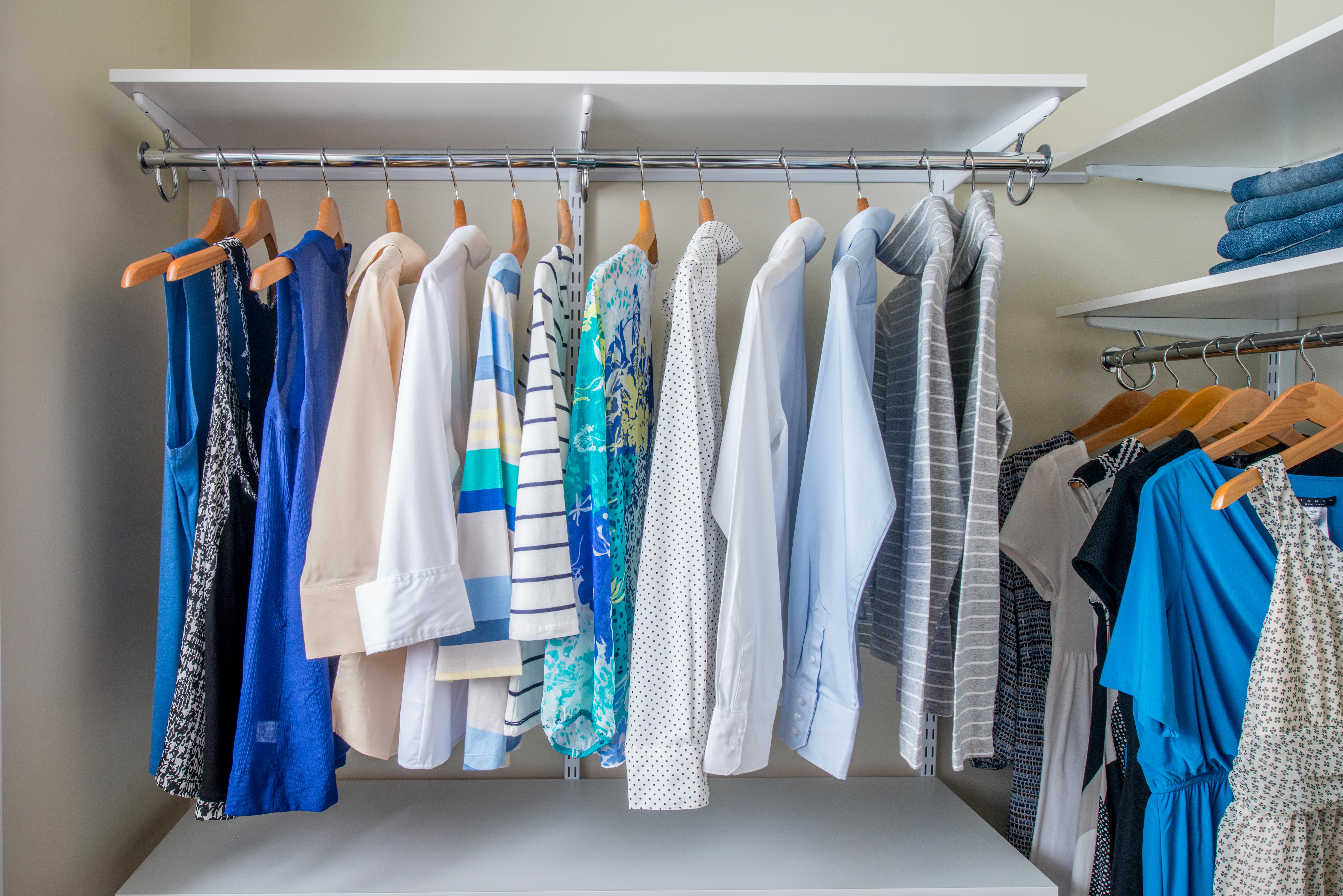 freedomRail Walk-in Closet in White with women's shirts and dresses.